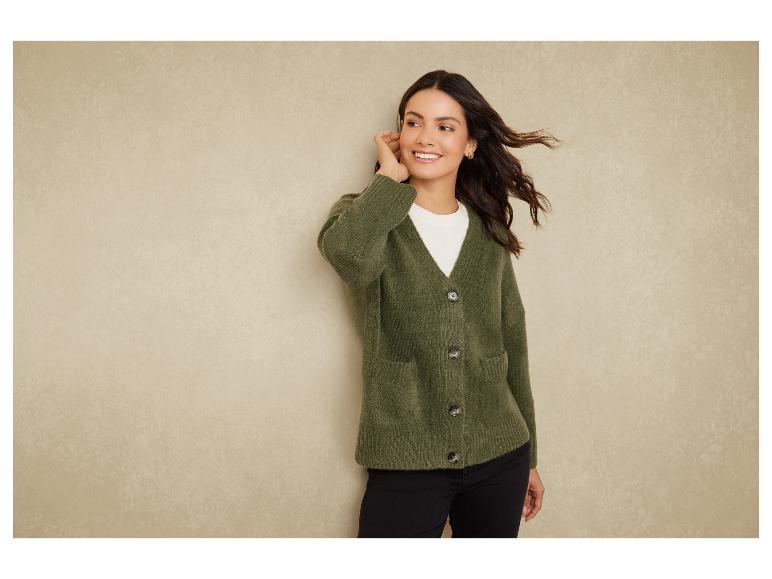 Eine Frau trägt einen grünen Strickpullover mit Knöpfen.