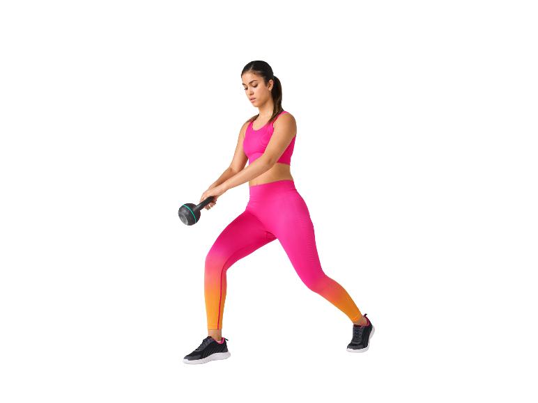 Frau in rosa Sportkleidung trainiert mit einer Kettlebell.