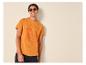 Mann in orangefarbenem T-Shirt mit Surf-Print und Sonnenbrille, lächelnd.