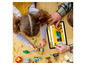 Ein Kind baut mit LEGO Classic Steinen und schaut auf ein Tablet mit LEGO Ideen.