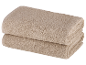 Zwei beige Frotteehandtücher, gefaltet.