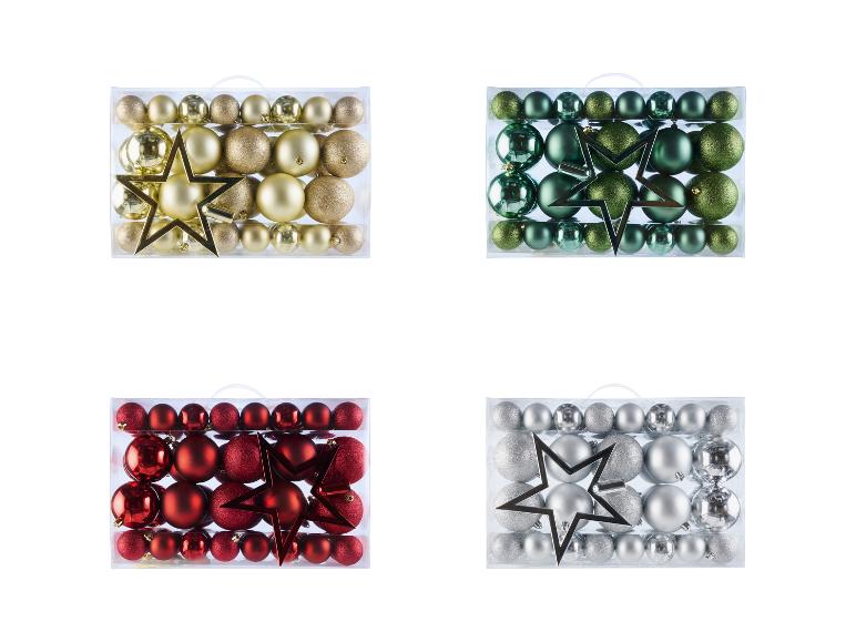 Vier Schachteln mit Weihnachtsschmuck in Gold, Grün, Rot und Silber.