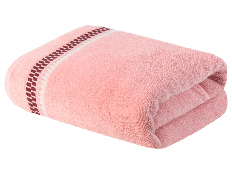 Ein rosa Handtuch mit dunkelrotem und weißem Rand.