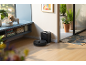 Saugroboter mit Ladestation in einem modernen Wohnzimmer mit Pflanzen und Dekoration.