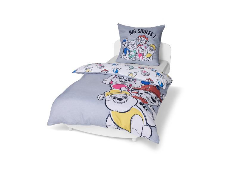 Kinderbettwäsche-Set mit Kissen und Bettdecke, mit Cartoon-Hundemotiven und dem Text „BIG SMILES!“.