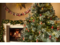 Verschneiter Weihnachtsbaum mit Dekorationen und brennendem Kamin, Girlande und Adventskalender.
