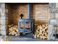 Holzofen mit brennendem Feuer, Holzstapeln und Kaminbesteck.