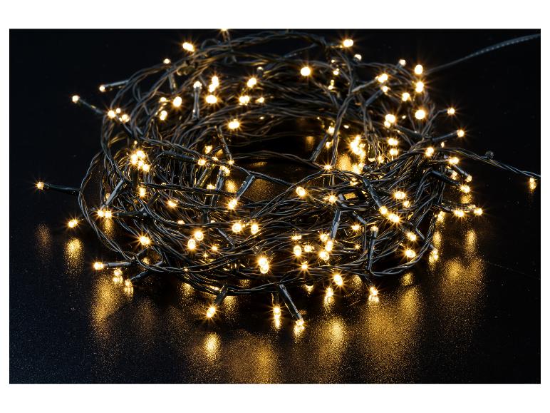 Warmweiße LED-Weihnachtsbeleuchtung, auf einer schwarzen Oberfläche aufgerollt