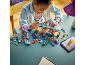 Ein Kind baut ein Spielzeughaus mit Figuren und Zubehör auf einem Tisch, eine Anleitung auf dem Tablet nutzend.