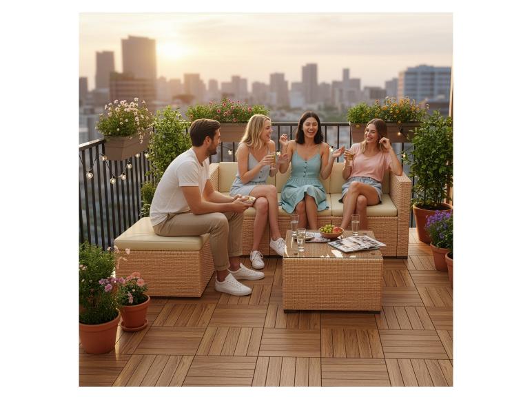 Freunde genießen ein Outdoor-Sofa aus Rattan auf einer Dachterrasse mit Stadtblick.