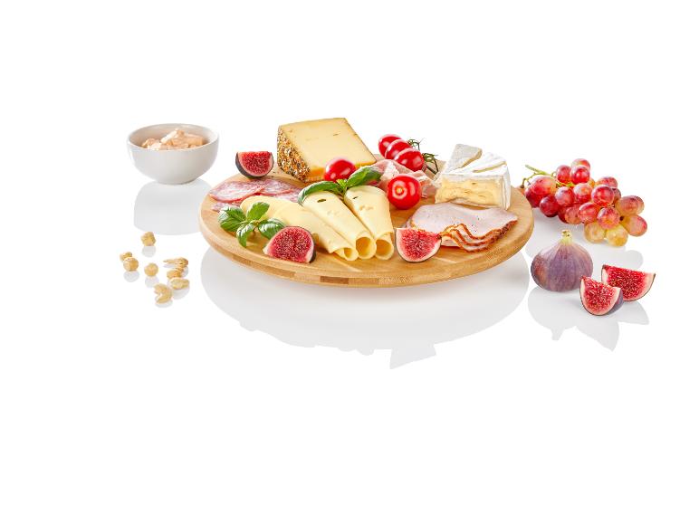 Käse, Aufschnitt, Feigen und Trauben auf Holzbrett.