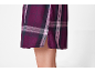 Lila kariertes Kleid mit seitlichem Schlitz, der einen Teil des Beines zeigt.