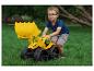 Ein kleiner Junge mit Brille spielt mit einem großen gelben Spielzeugbagger auf grünem Gras.