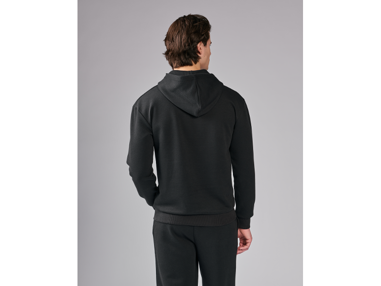 Mann in schwarzem Kapuzenpullover und Jogginghose, Rückansicht.