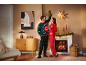 Ein Paar in festlichen Weihnachts-Pyjamas und Pullovern posiert unter einem Mistelzweig am Kamin.