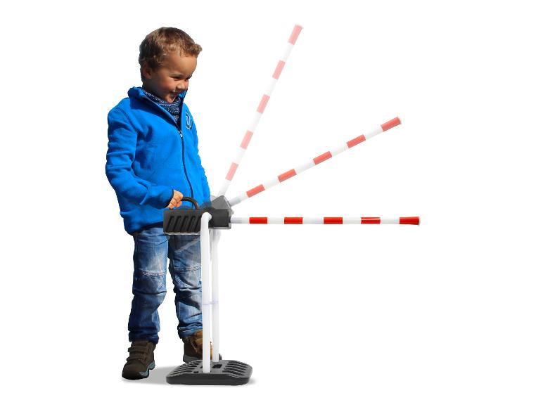 Ein kleiner Junge spielt mit einem Spielzeug-Bahnübergang.