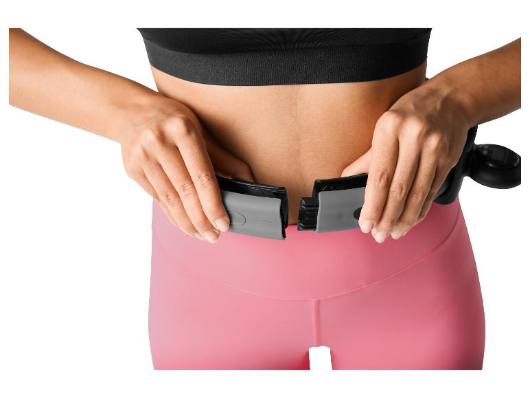 Frau passt einen smarten Fitness-Hula-Hoop um ihre Taille an.