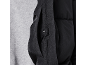 Detail einer schwarzen Steppjacke mit Seitentasche und Druckknopf.
