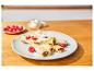 Schokoladen-Crêpes mit Himbeeren und Puderzucker auf einem Holztisch.