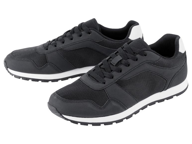 Zwei schwarze Sneaker mit weißen Sohlen.