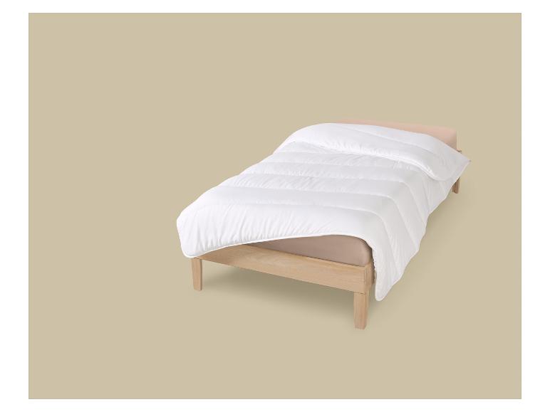 Einzelbett mit weißer Bettdecke und beigem Laken auf beigem Hintergrund