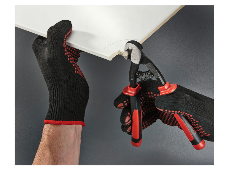 Hände in Arbeitshandschuhen, die Knipex-Zangen zum Schneiden einer weißen Fliese verwenden.