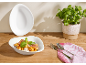 Rigatoni-Pasta mit Parmaschinken, Ricotta und frischem Basilikum in einer weißen Schale, mit Basilikumpflanze.
