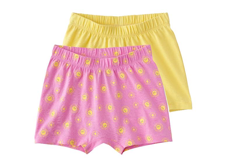 Zwei Mädchenshorts, eine rosa mit Sonnen und eine gelbe.