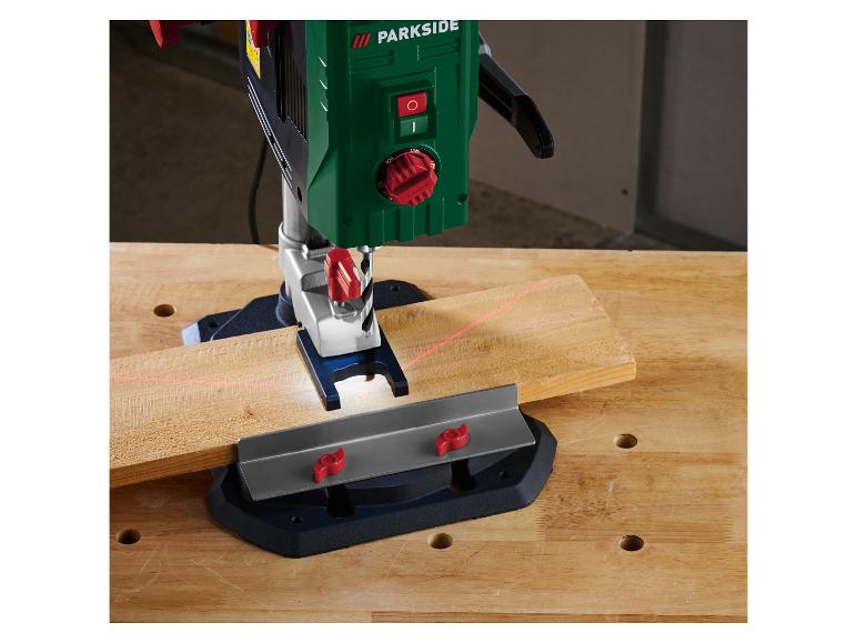 Bohrständer mit Laser und Holzstück auf einer Werkbank.