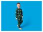 Lächelnder Junge in grünem Pyjama mit Weihnachtsmann und Sternen