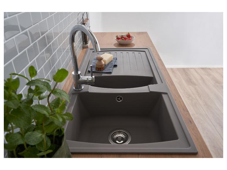 Moderne graue Küchenspüle mit Chromarmatur, Holzarbeitsplatte und grauem Fliesenspiegel.