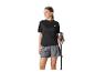 Frau in schwarzem T-Shirt und grauen Shorts, Wanderstöcke haltend.