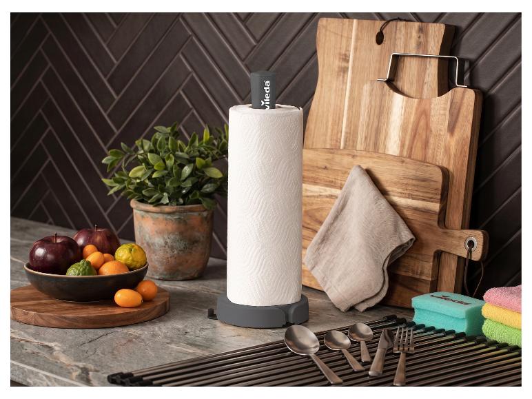 Grauer Küchenrollenhalter mit Obst, Schneidebrettern und Küchenutensilien.