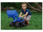 Junge mit blauem Spielzeugbagger spielt auf dem Rasen.