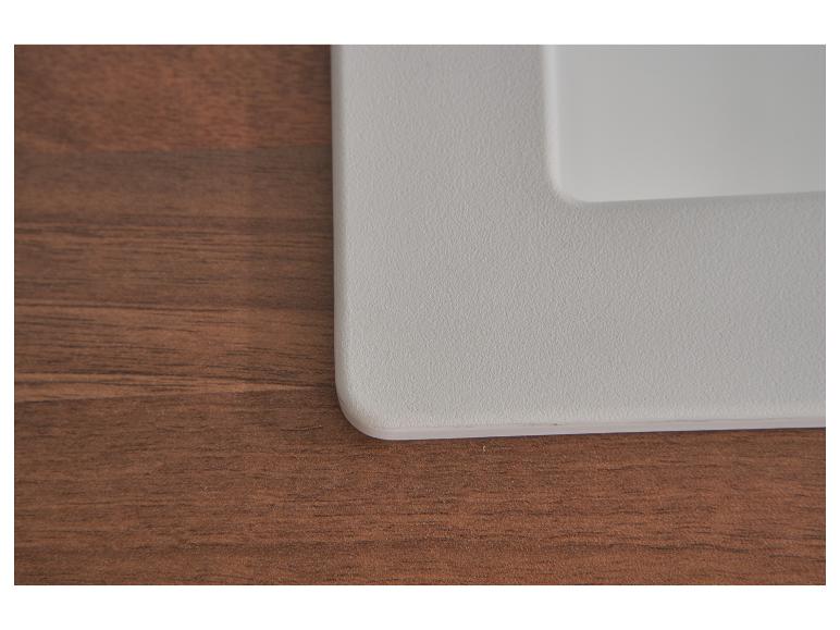 Graue Kunststoffoberfläche auf braunem Holzhintergrund.