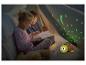 Zwei Kinder lesen ein Buch in einem Zelt mit einer Schildkröten-Nachtlampe, die Sterne projiziert.
