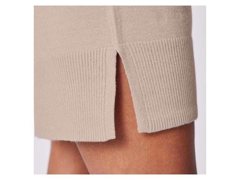 Nahaufnahme eines beigen Strickrocks mit Schlitz.
