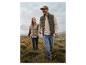 Mann und Frau in der Natur, tragen gesteppte Westen und Jeans.
