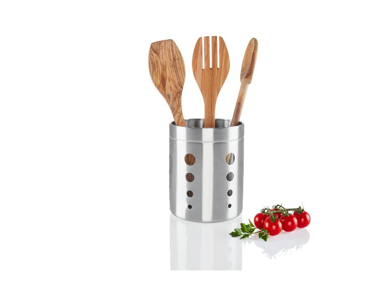 Hölzerne Küchenutensilien in einem Stahlhalter mit Tomaten.