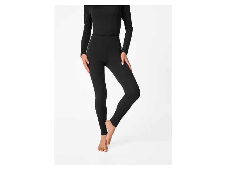 Eine Person trägt ein schwarzes Langarmshirt und schwarze Leggings.