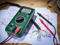 Ein grünes Parkside Digitalmultimeter mit Testsonden auf einem Schema.