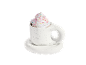 Heiße Schokolade mit Schlagsahne und bunten Streuseln in einer weißen Tasse mit Untertasse