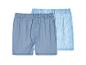 Zwei Herren-Boxershorts: eine einfarbig blau, eine blau-weiß gestreift.