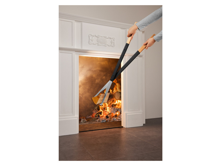 Zwei schwarze Zangen mit Holzgriffen zum Anfeuern eines Kamins.