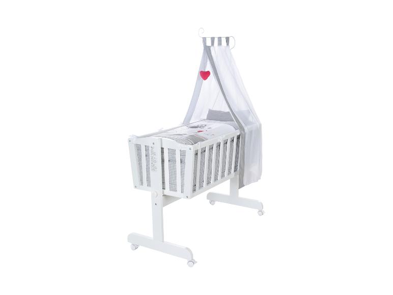 Weißes Babybett mit Himmel und grauer gemusterter Bettwäsche