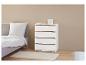 Eine weiße Kommode mit vier Schubladen in einem Schlafzimmer.