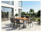 Garten-Essgruppe mit Holztisch und Korbstühlen auf einer modernen Terrasse.