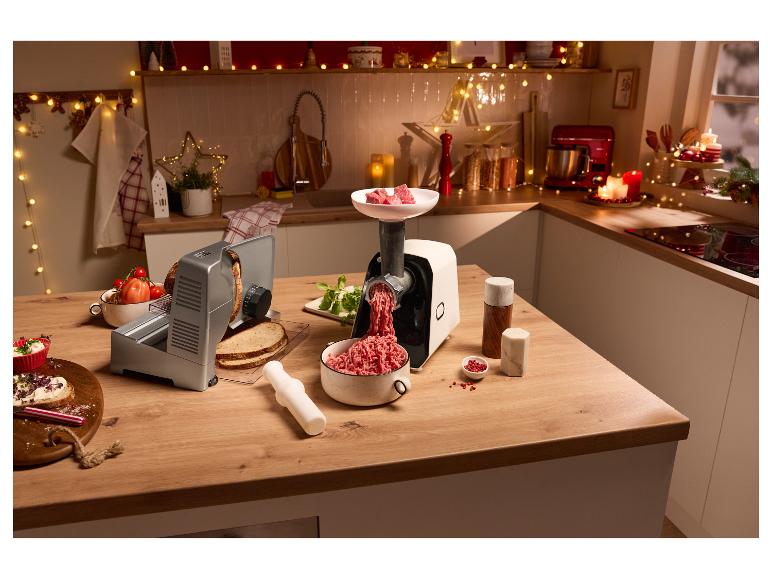 Fleischwolf und Brotschneidemaschine auf einer weihnachtlich dekorierten Küchenzeile.