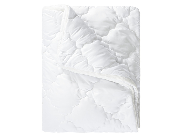 Eine weiße, gesteppte Bettdecke für zusätzliche Wärme.