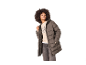 Frau in brauner Steppjacke, gemustertem Pullover und Jeans.